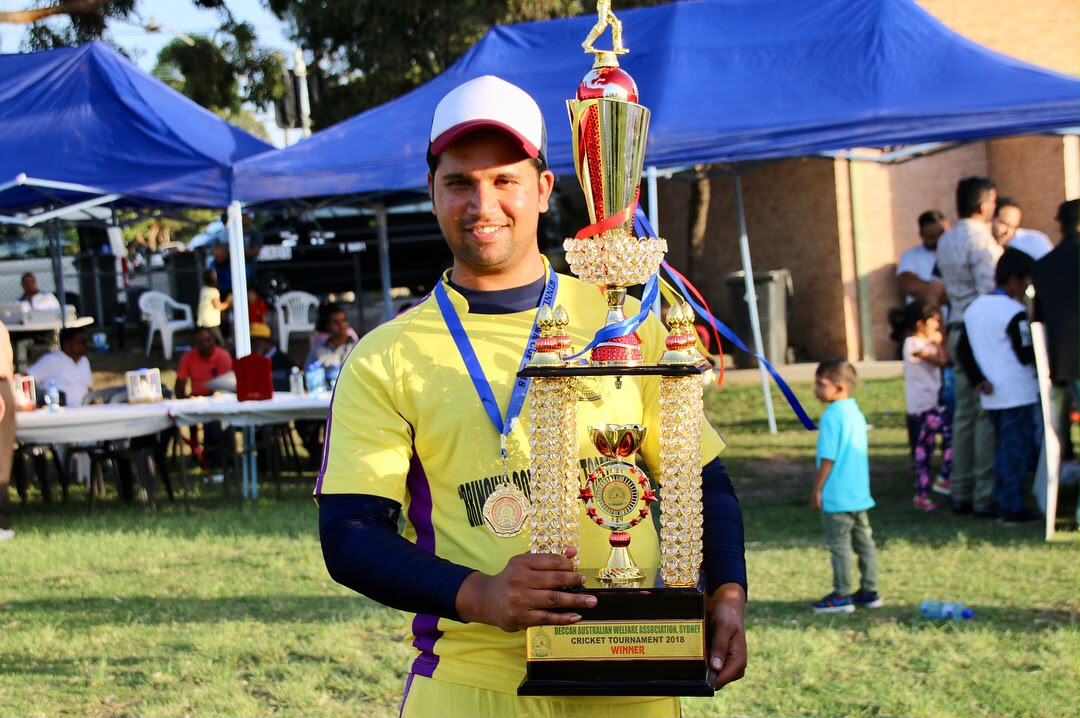 Sydney Chargers player holding the 2018 cricket tournament winner trophy